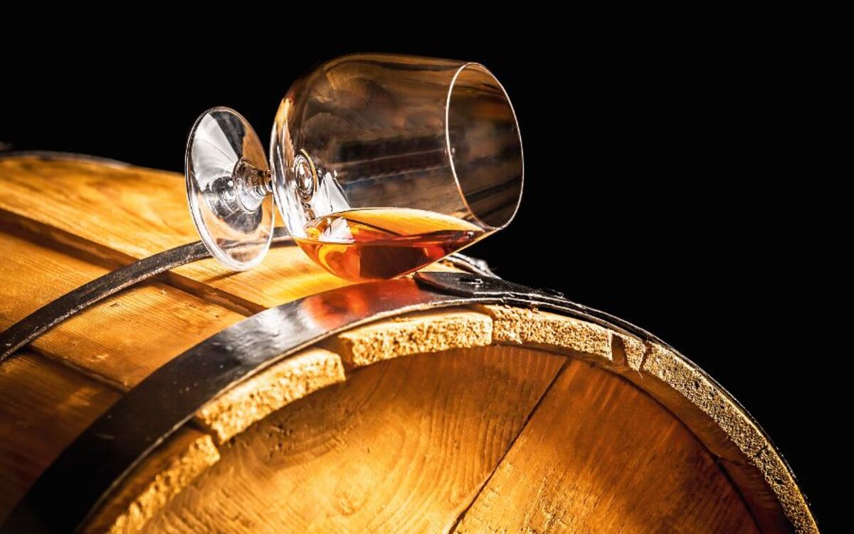 Cognac-Glas auf einem Holzfass
