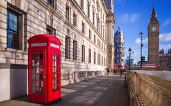 rote Telefonzelle mit Big Ben und Doppeldeckerbus im Hintergrund in London