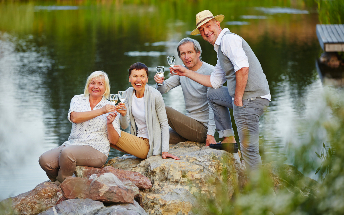 Senioren sitzen am See im Sommer
