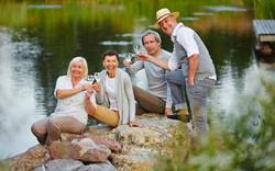 Senioren sitzen am See im Sommer
