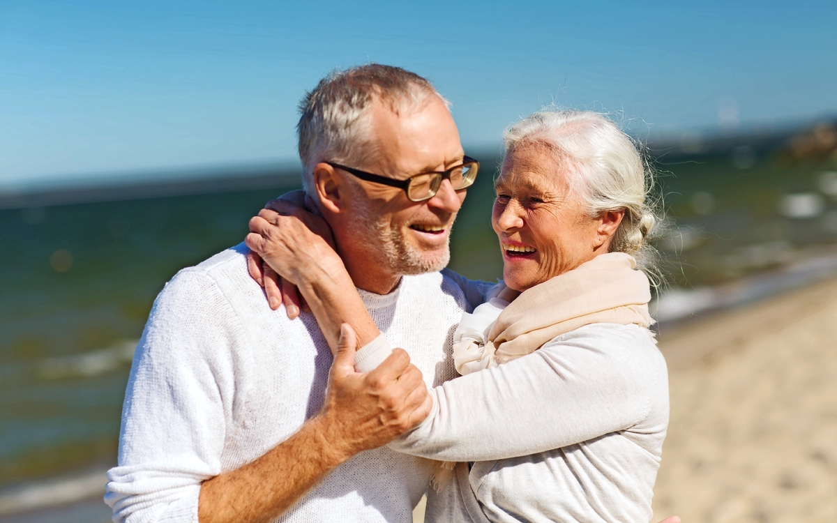 glückliches älteres Paar umarmt sich am Strand