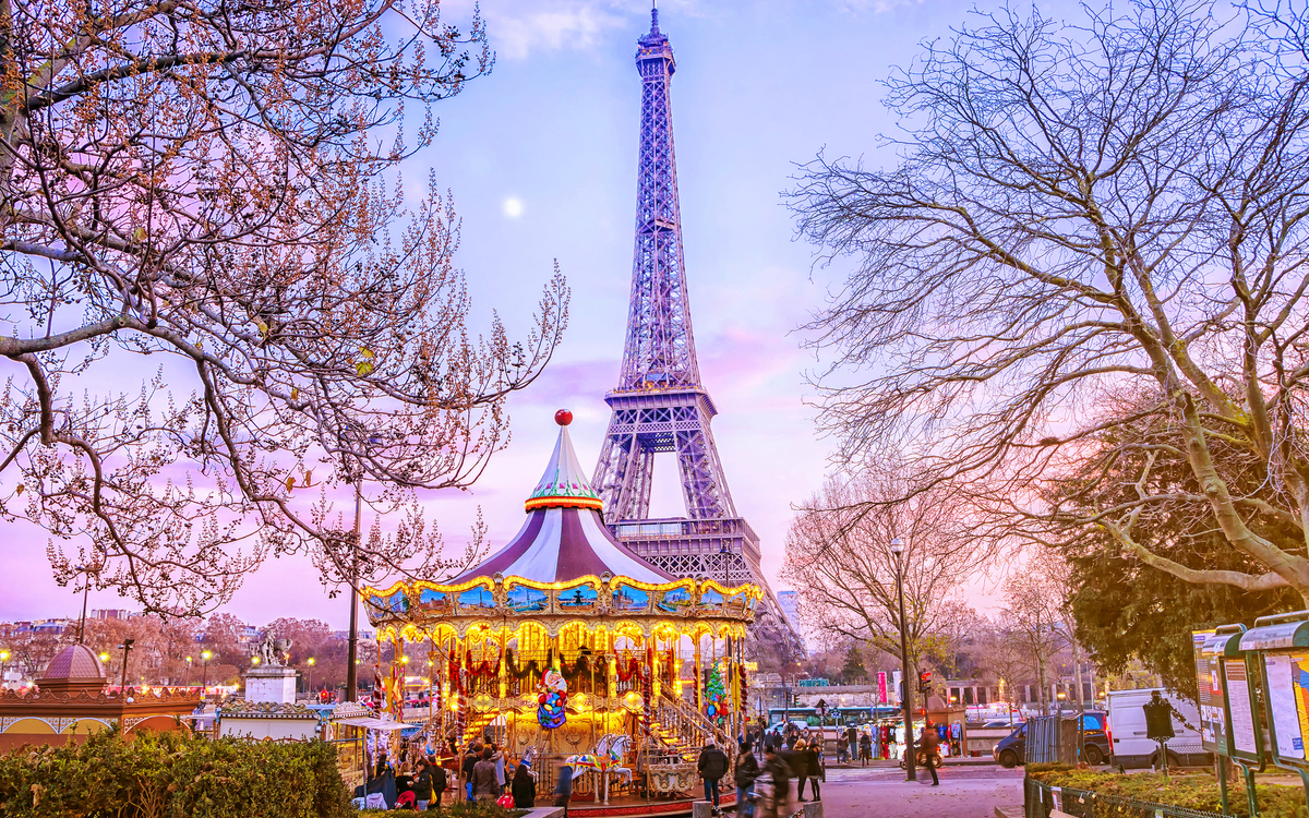 Eiffelturm hinter Karussell an einem Winterabend in Paris