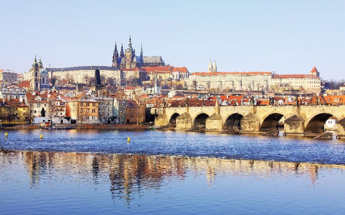Snowy Prague gothic Castle with Charles Bridge in the sunny Day