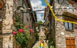 Pilgerin wandert auf einem Wanderweg durch die alte mittelalterliche Stadt Queralbs