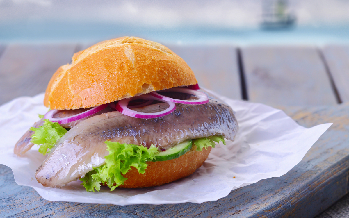 Matjesbrötchen auf einem Teller vor der Nordsee