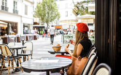 Frau mit einem französischen Frühstück im Café