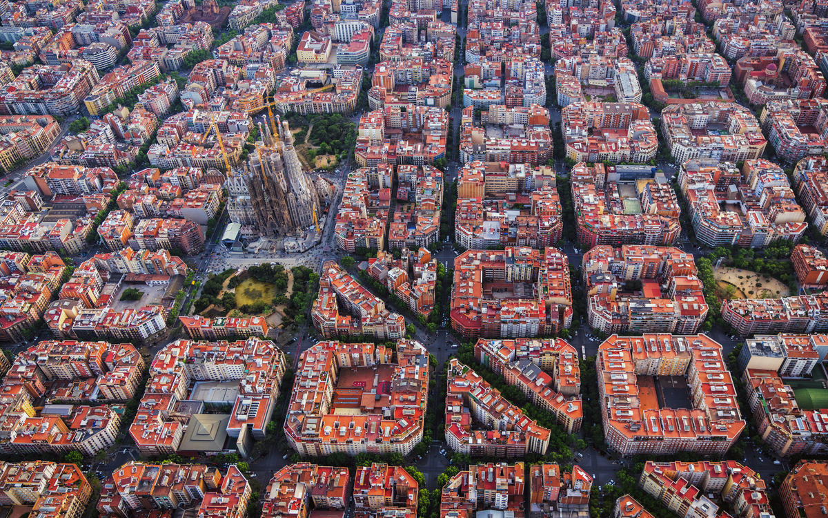 Luftaufnahme von Barcelonas schachbrettartig angelegtem Stadtviertel Eixample und der Kathedrale Sagrada Familia