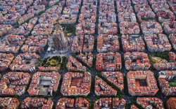 Luftaufnahme von Barcelonas schachbrettartig angelegtem Stadtviertel Eixample und der Kathedrale Sagrada Familia