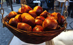 kleiner Korb mit gerösteten Kastanien, die auf dem traditionellen Weihnachtsmarkt auf dem Altstädter Ring verkauft werden, Prag