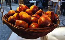 kleiner Korb mit gerösteten Kastanien, die auf dem traditionellen Weihnachtsmarkt auf dem Altstädter Ring verkauft werden, Prag