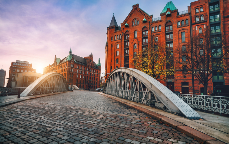 Brücke aus Kopfsteinpflaster in der Speicherstadt, Hamburg bei Sonnenuntergang.