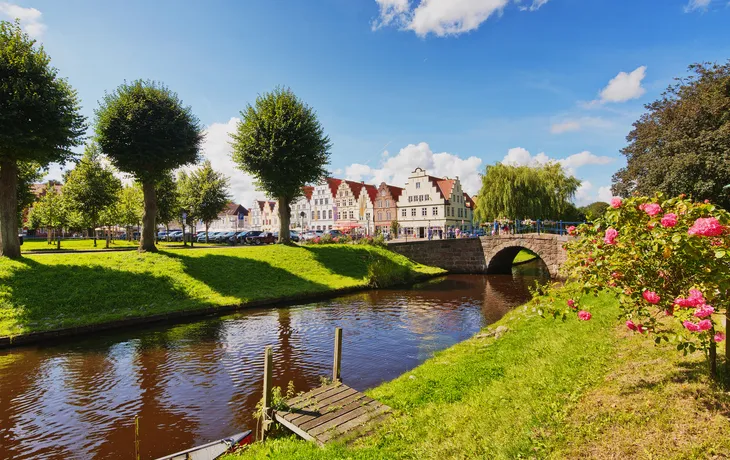 Kanalansicht im Luftkurort Friedrichstadt bei sonnigem Wetter mit historischen Häusern.