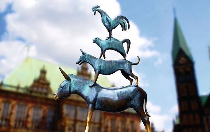 Bronzestatue der Bremer Stadtmusikanten vor einem historischen Gebäude.