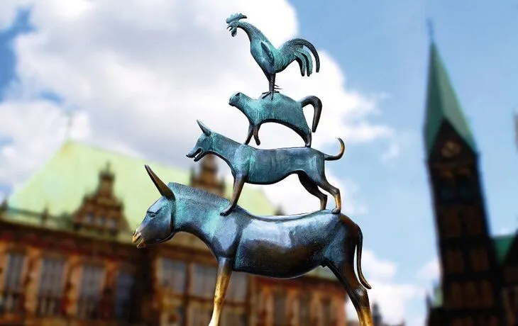 Bronzestatue der Bremer Stadtmusikanten vor einem historischen Gebäude.