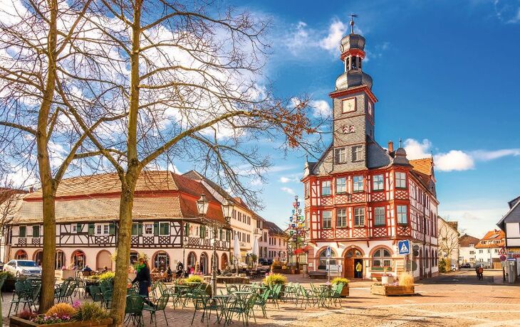 Historisches Fachwerkhaus und leerer Platz bei Sonnenschein.