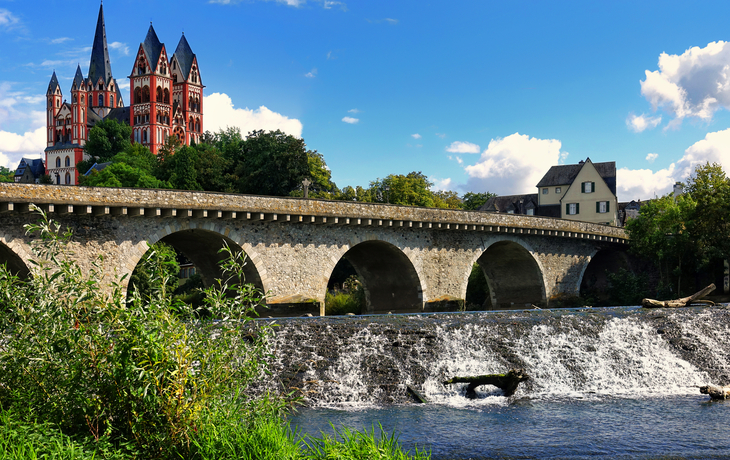 Historische Steinbrücke und Limburger Dom bei sonnigem Wetter.