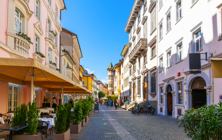 Malerische italienische Straßenszene mit historischen Gebäuden und Straßencafé.